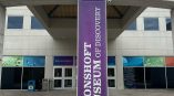 Concrete building sign with raised letters and a vertical fabric banner in Dayton, Ohio.