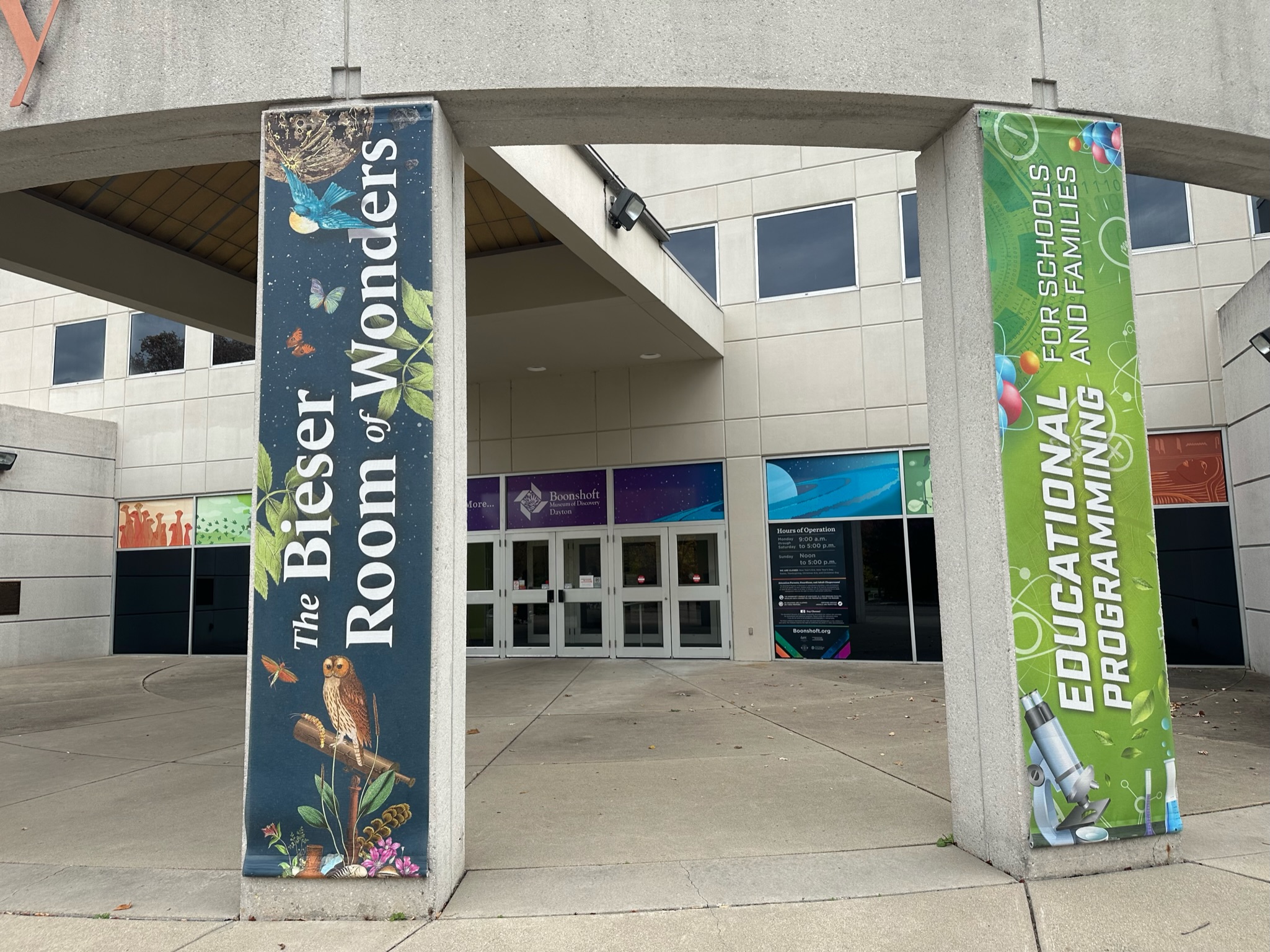 Two vertical fabric banners with printed graphics on concrete pillars in Dayton, Ohio.