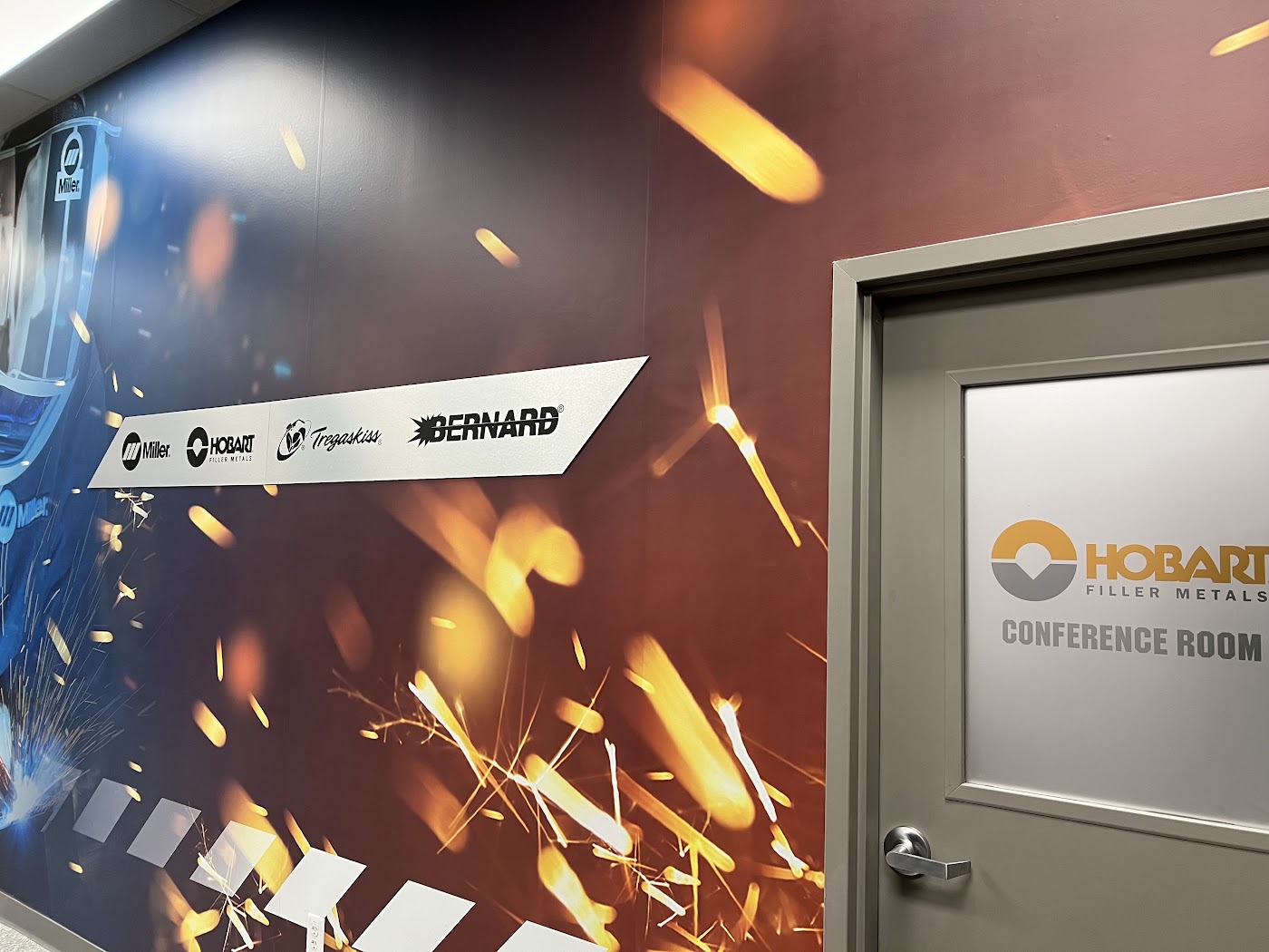 Frosted glass conference room door and large printed wall mural with arrow sign in Dayton, Ohio.
