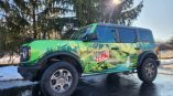 Full commercial vehicle wrap with mountain and nature graphics on a green SUV in Dayton, Ohio.