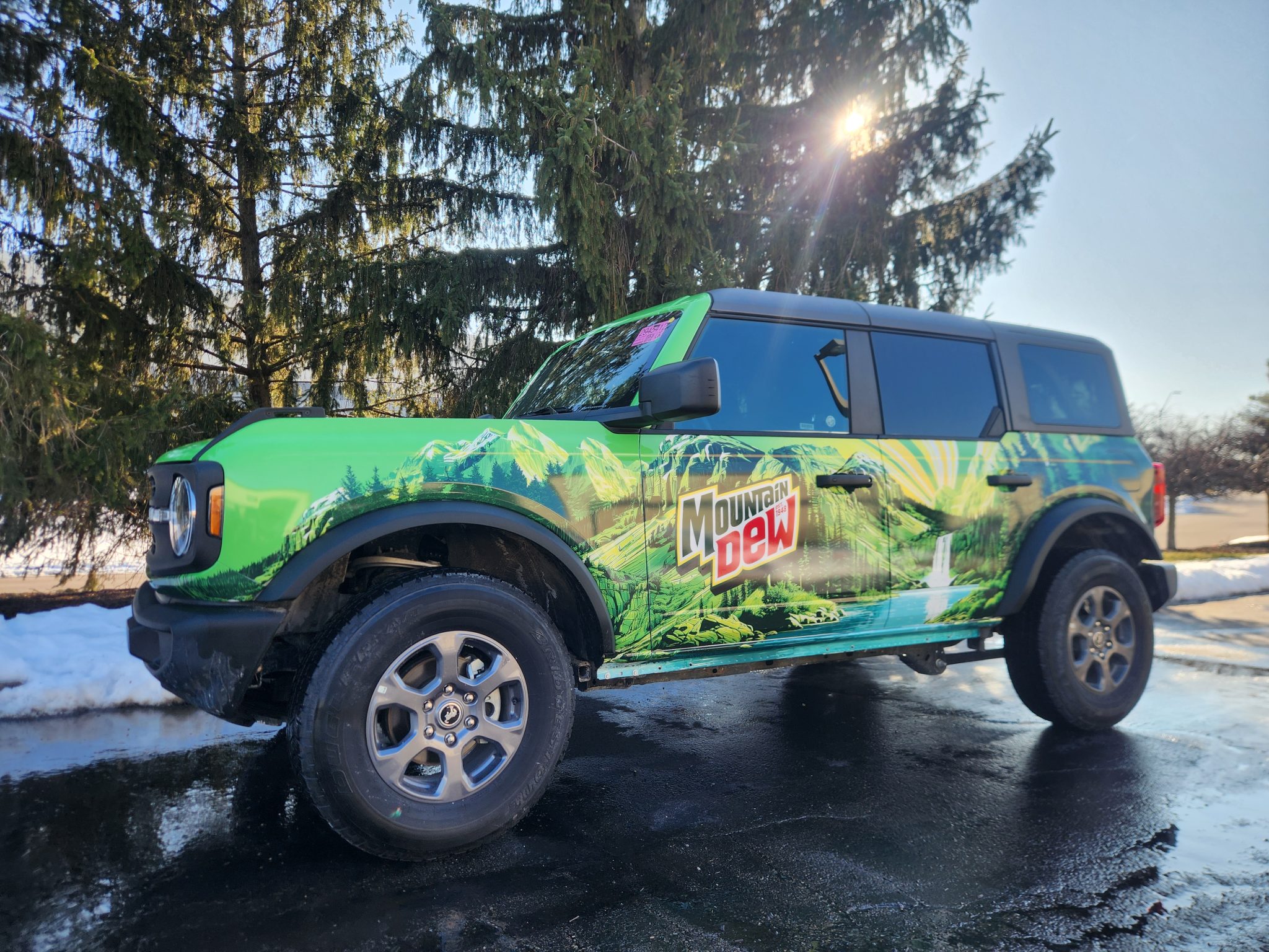 Full commercial vehicle wrap with mountain and nature graphics on a green SUV in Dayton, Ohio.