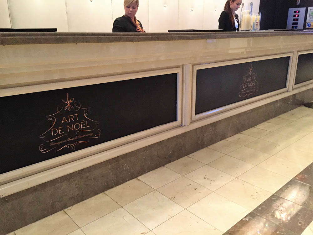 A hotel logo printed on the front desk in a hotel lobby.