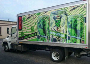 A large box truck with a custom vehicle wrap showing beer cans and hops for Revolution Brewery.