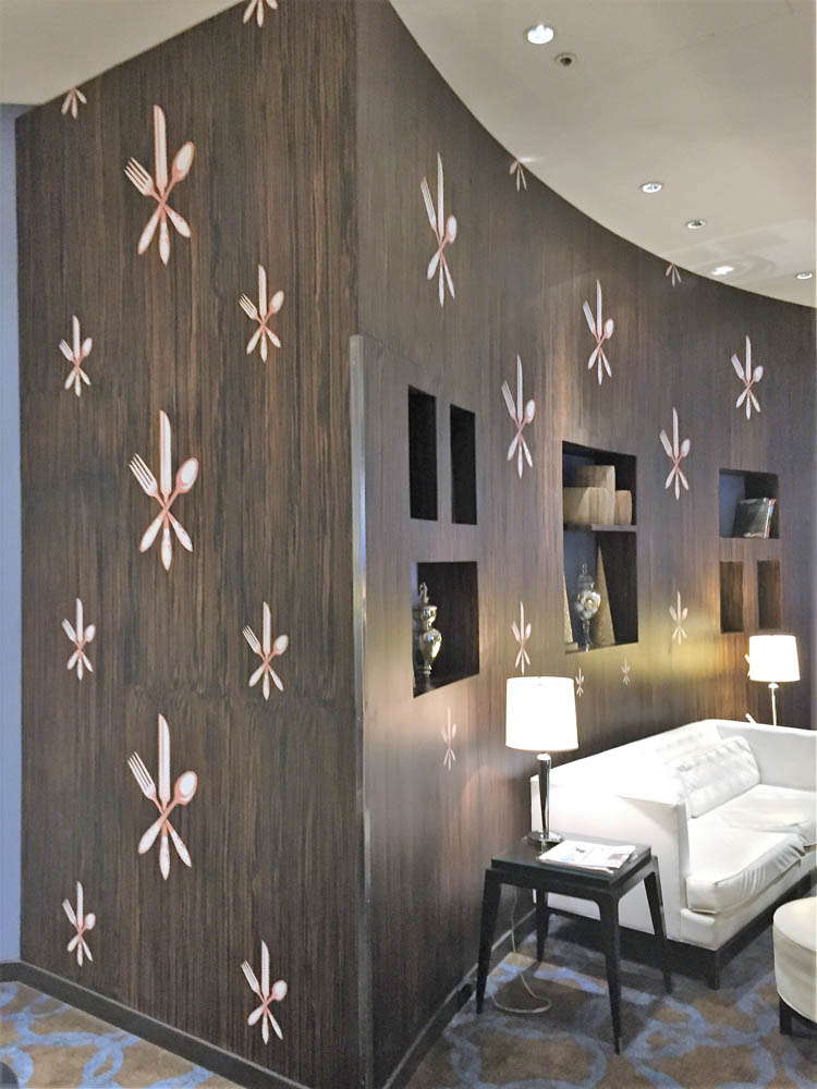 A custom wall graphic showing cutlery in a cross pattern in a hotel.