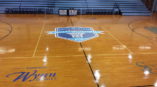 A custom designed sports team logo at the center of a basketball court.