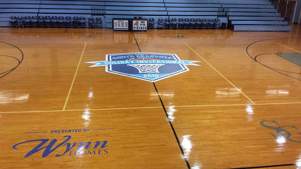 A custom designed sports team logo at the center of a basketball court.