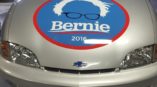 A Bernie Sanders campaign logo on the hood of a small Chevy car.