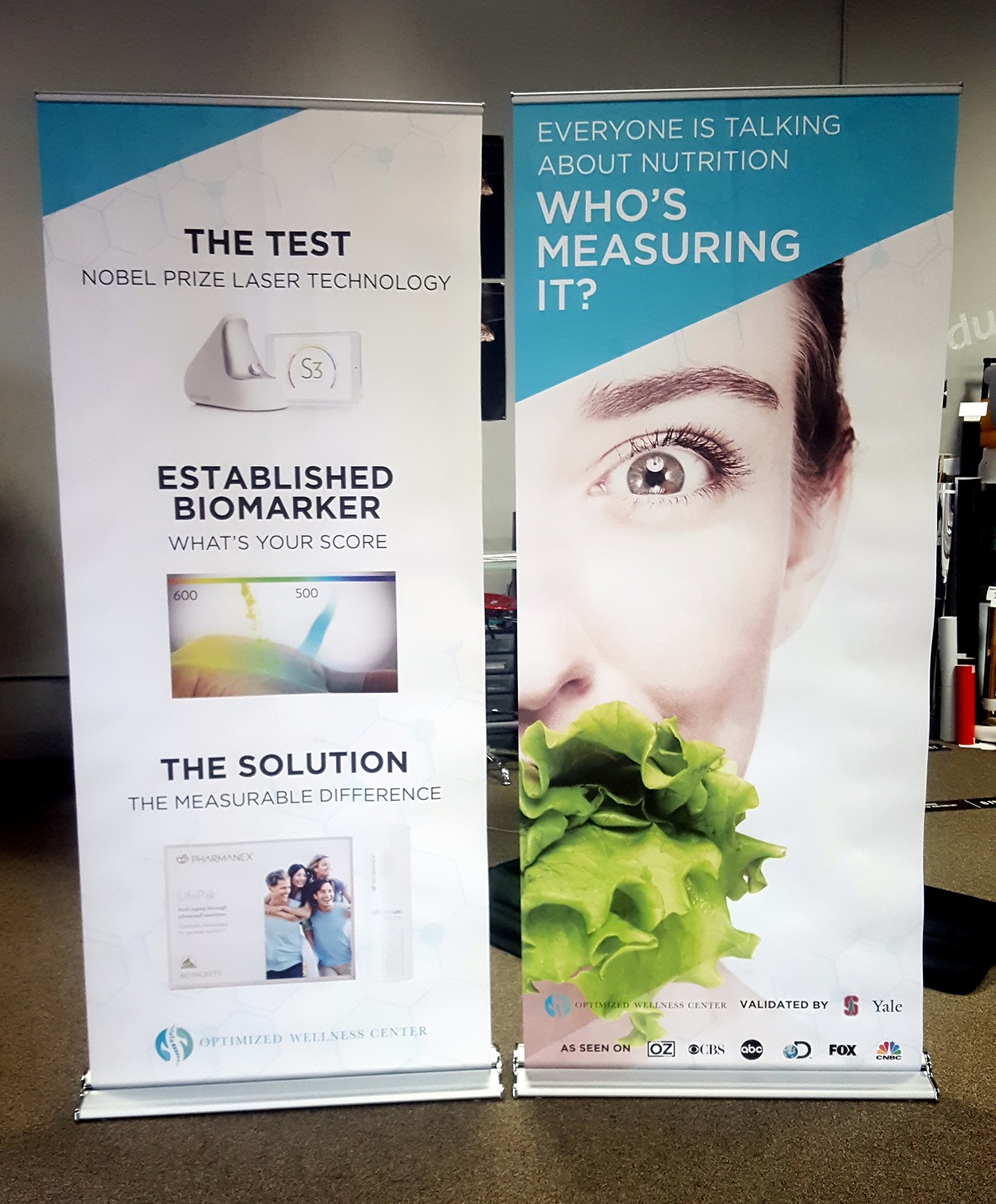 Two personalized banner stand ads for a wellness company.