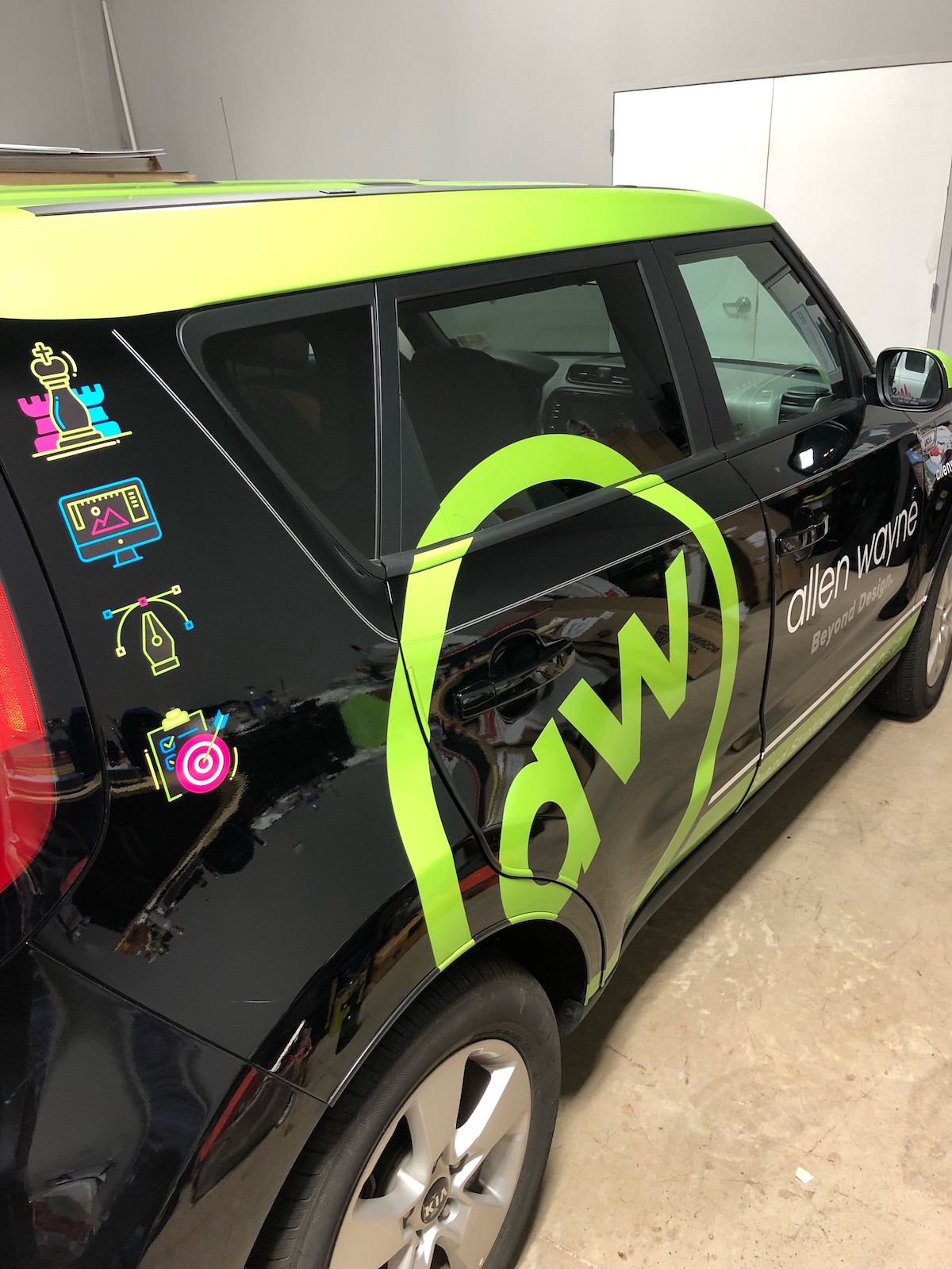 Car door with automotive decal and logo, highlighting a sleek vehicle wrap aesthetic.