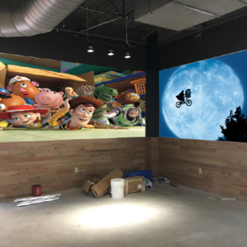 Two wall murals with images of the Toy Story gang and ET iconic scene  