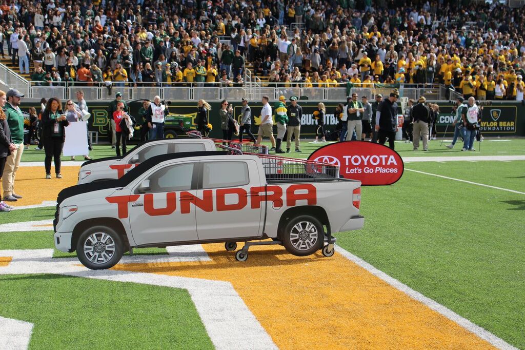 Toyota tailgate toss on a football field featuring shopping carts with cutouts of Toyota Tundra trucks 