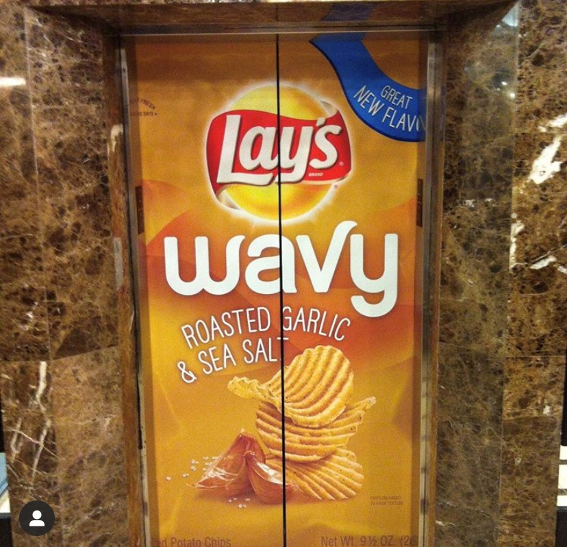 Branded elevator wrap featuring Lays Wavy roasted garlic and sea salt chips, highlighting junk food.