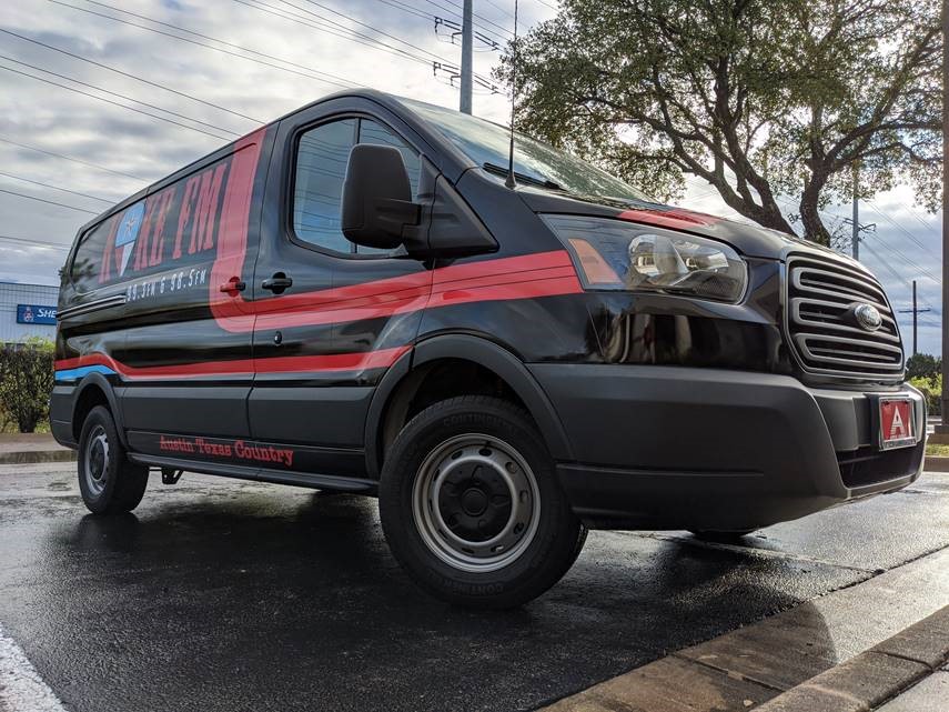 Black and red motor vehicle with automotive tire parked on road