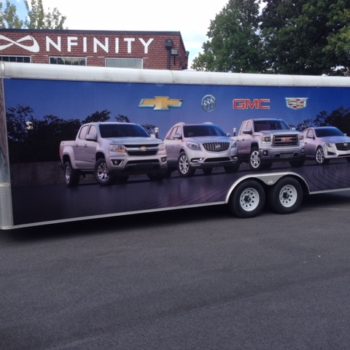 Trailer with vehicle wrap of chevy, buic, gmc and cadillac cars