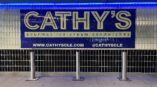 Blue Cathys sign on glass block wall