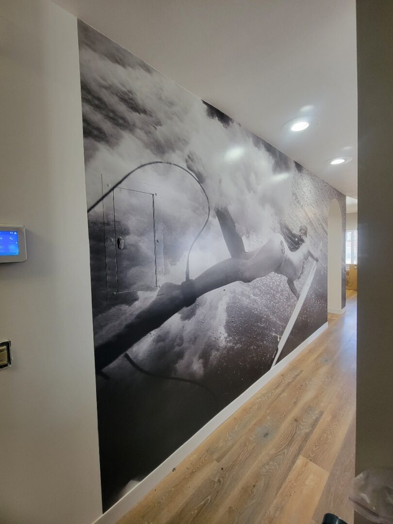 Grayscale vinyl mural of a surfer