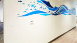 Cut vinyl of fish and stylized waves across middle of wall