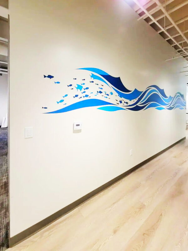 Cut vinyl of fish and stylized waves across middle of wall