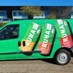 Van with full vehicle wrap of drink cans for Runa in front of building