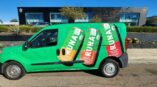Van with full vehicle wrap of drink cans for Runa in front of building