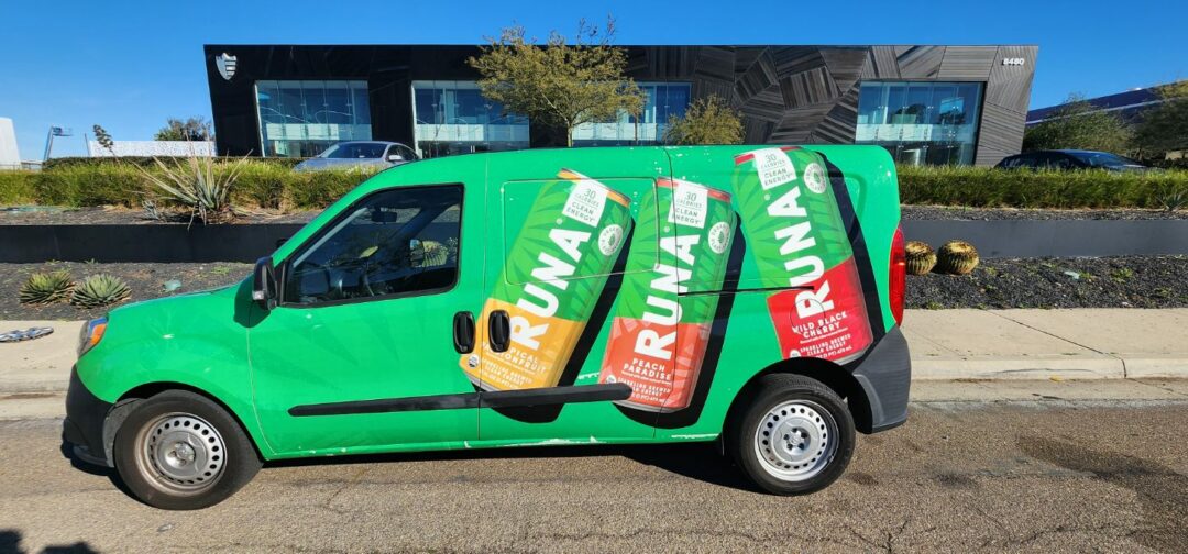 Van with full vehicle wrap of drink cans for Runa in front of building