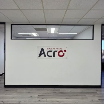 Rectangular acrylic wall sign mounted with standoffs on white wall in office space San Diego, CA.