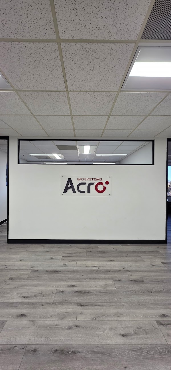 Rectangular acrylic wall sign mounted with standoffs on white wall in office space San Diego, CA.