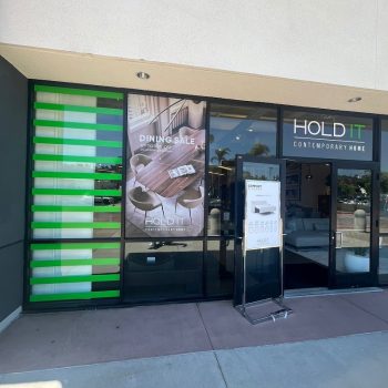 Retail storefront window graphics with green stripes and promotional vinyl decals in San Diego, CA.