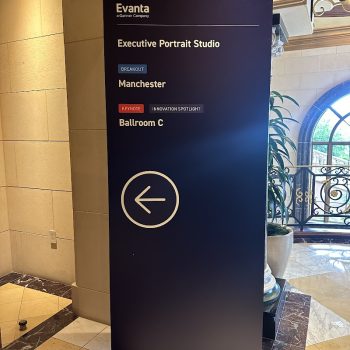 Freestanding directional sign with arrow graphic and text on black panel in San Diego, CA.