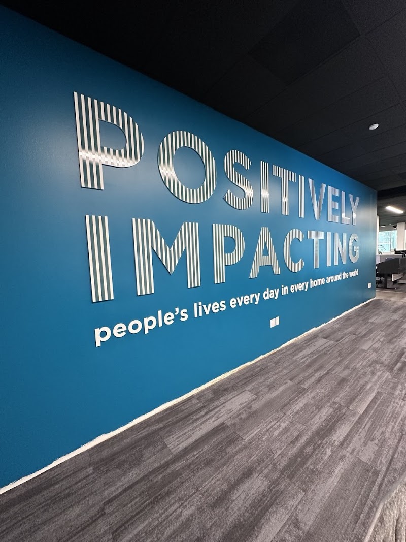 Striped acrylic wall letters mounted on a blue wall in an office interior in San Diego, CA.