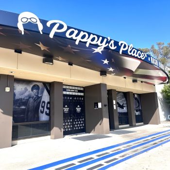 Curved storefront channel letter sign with printed window graphics in San Diego, CA.
