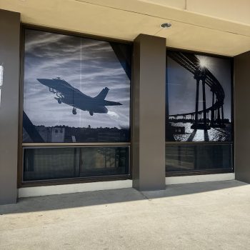 Two large black and white window graphics featuring an airplane and a bridge in San Diego, CA.