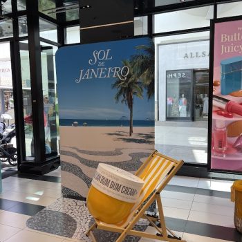 Freestanding fabric display with beach scene and oversized product prop in retail space in San