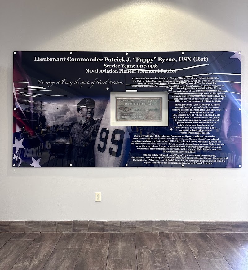 Large acrylic wall sign with military tribute graphics and text mounted on a white wall in San