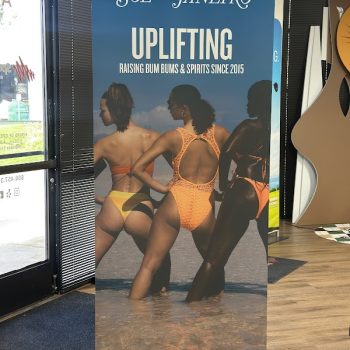 Retractable vinyl banner with beach image and text standing indoors in San Diego, CA.