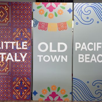 Three colorful printed directional signs on rigid panels with decorative designs in San Diego, CA.