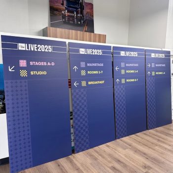 Set of large printed wayfinding signs with directional arrows on rigid panels in San Diego, CA.