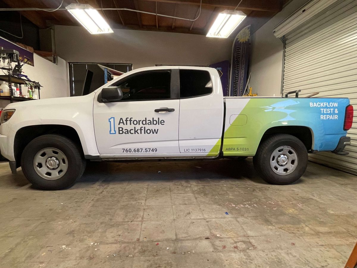 Partial commercial vehicle wrap with blue and green gradient on white pickup truck in San Diego, CA.