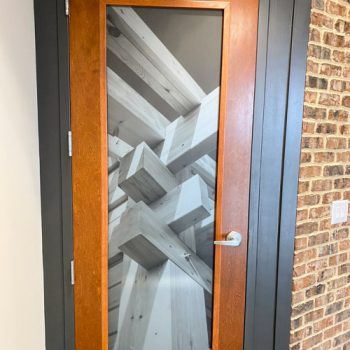 Custom door window display combining a wood pattern on clear vinyl and privacy frosting.