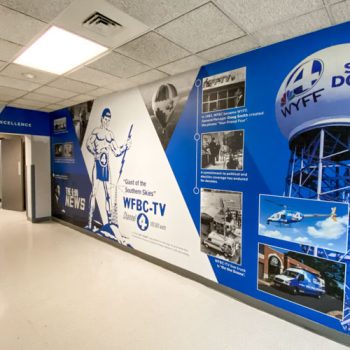 Hallway wall mural with photos and captions from WYFF's time in Greenville.