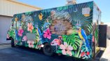 Full, tropical themed food truck wrap with bright colors and a rainforest habitat.