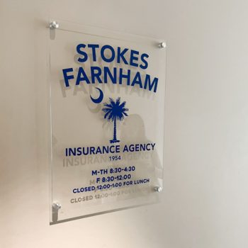 Logo and office hours on an interior acrylic display.