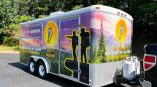 Full food trailer wrap with a mountain horizon background and logo graphics.
