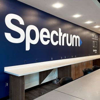 Large blue wall mural with Spectrum's logo in business cafeteria.