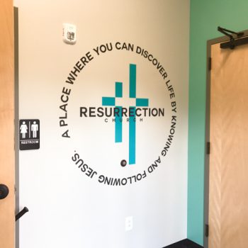 Die-cut wall decal of a logo with circling text.