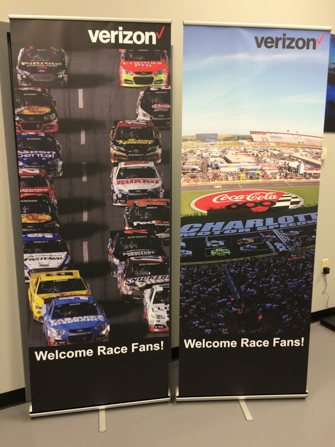 Two Verizon retractable banners with images of a racetrack.