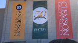 Wide-format banners hanging from the side of a building representing universities.