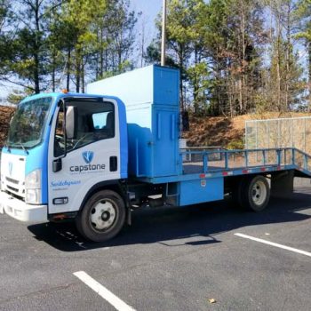 Landscaping Isuzu cab partially wrapped in solid blue and company logos.
