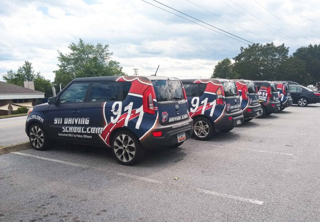 Row of fully wrapped 911 Driving School fleet vehicles