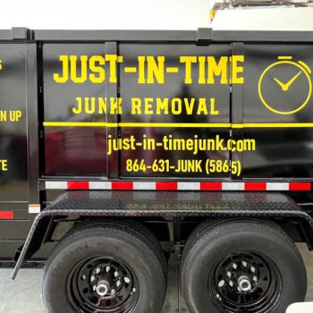 Yellow logo and services decals on the sides of Just-In_Time's dump trailer
